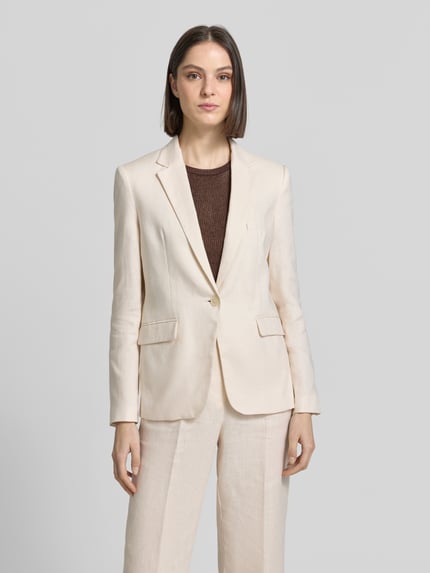 Frauenmodel trägt Blazer mit Pattentaschen Modell 'Boreli' von Mango aus Reine Baumwolle, taillierte Passform, Reverskragen, Ganzkörperansicht von vorne.