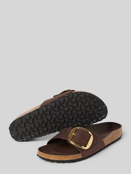Produktfoto, Slides aus Leder mit Dornschließe Modell 'Madrid Big Buckle' von Birkenstock in Braun mit profilierter Sohle und Logo-Prägung.