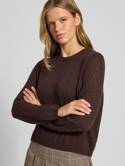 Frauenmodel trägt Regular Fit Pullover mit gerippten Ärmelbündchen Modell 'ADA' von PIECES in Dunkelbraun, Strukturstrick, Nahaufnahme Oberkörper. Damen Pullover von PIECES.