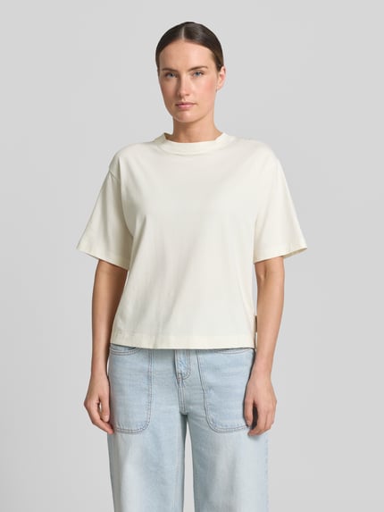 Vrouwenmodel draagt Regular-Fit T-shirt uit katoenmix van Marc O'Polo, dames, in licht crème met rechte lijnen, voorkant totaalbeeld.