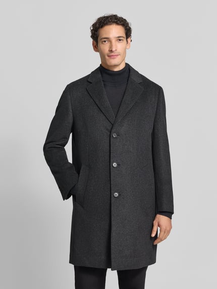Männermodel trägt Mantel mit Reverskragen und Eingrifftaschen von bugatti in Anthrazit, Knopfleiste, Regular Fit, Ganzkörperansicht von vorne. Kontext: Rückenlänge bei Größe 50: 99 cm, Schulterbreite: 45 cm, Brustweite: 57 cm, Ärmellänge: 66 cm.