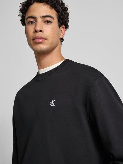 Männermodel draagt Sweatshirt mit Label-Stitching van Calvin Klein Jeans, zwart, katoen, geribde boorden, ronde hals, Nahaufnahme Oberkörper.