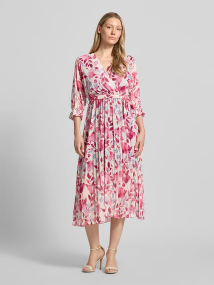 Frauenmodel trägt Midikleid mit Bindegürtel Modell 'Momoo' von ZABAIONE in Wickel-Optik, floral gemustert, 3/4-Arm, Taillierte Passform, Ganzkörperansicht von vorne.