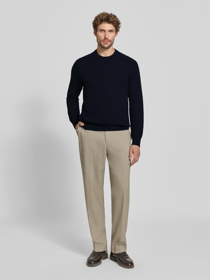 Männermodel trägt Regular Fit Strickpullover aus reinem Kaschmir von FTC Cashmere in Dunkelblau, kombinierbar, Ganzkörperansicht von vorne.