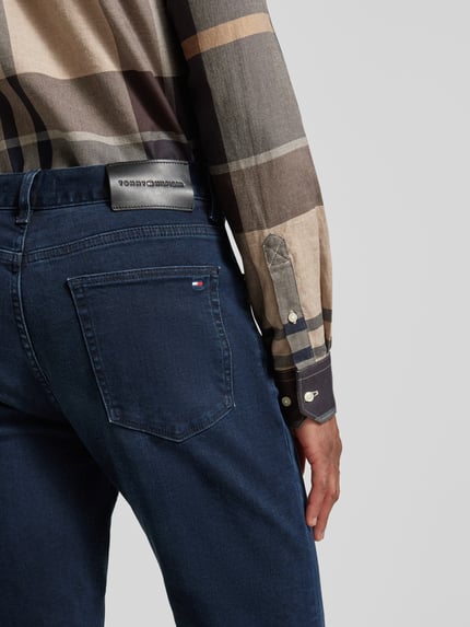 Mężczyzna nosi Slim Fit Jeans aus Baumwoll-Mix Modell 'BLEECKER' od Tommy Hilfiger, efekt melanż, denim, 5 kieszeni, naszywka z logo, widok z tyłu.