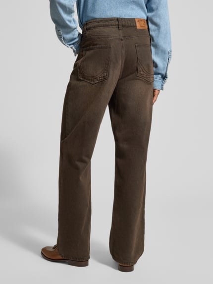 Männermodel trägt Relaxed Fit Jeans mit Knopf- und Reißverschluss von KARL KANI in Braun, 5-Pocket-Design, Label-Patch, Ganzkörperansicht Rückansicht