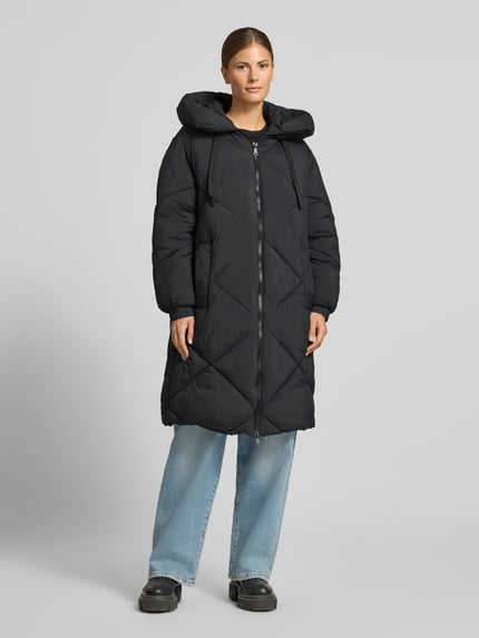 Frauenmodel trägt schwarzen Puffer Coat mit Zweiwege Reißverschluss von JAKE*S WOMAN CASUAL, Rautenstruktur, Longline, Kapuze, Ganzkörperansicht von vorne.
