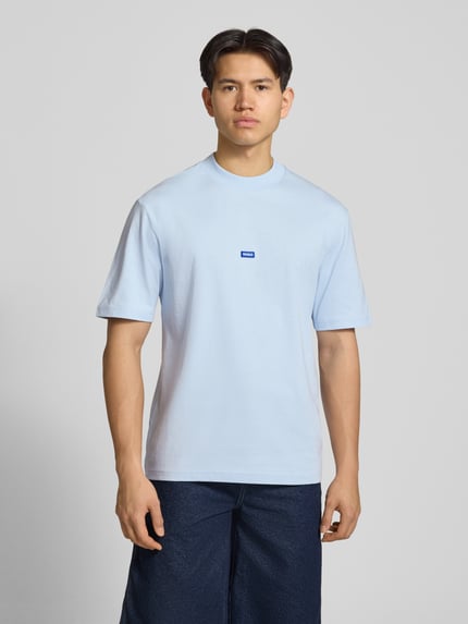 Męski model nosi Regular Fit T-Shirt aus reiner Baumwolle Modell 'NIEROS' von Hugo Blue, jasnoniebieski, logo, krótki rękaw, okrągły dekolt, materiał bawełna, jednolity kolor, Ganzkörperansicht von vorne.