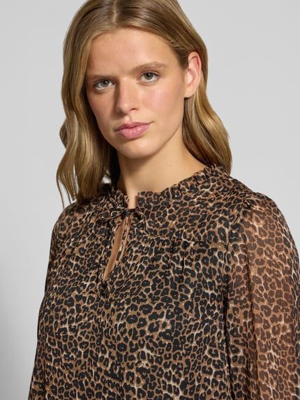 Frauenmodel trägt Regular Fit Langarmbluse mit Bindeverschluss Modell 'DITSY' von ONLY, Damen Langarmbluse, braun-schwarzes Leopardenmuster, leichte Transparenz, Nahaufnahme Oberkörper.