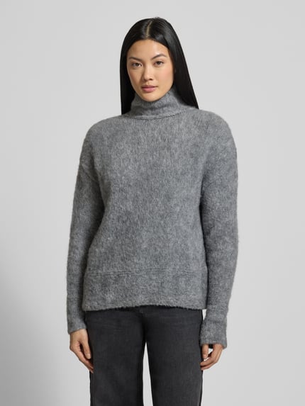 Frauenmodel trägt Strickpullover mit Stehkragen und überschnittenen Schultern von Milano Italy, grauer Material-Mix, Ganzkörperansicht von vorne.