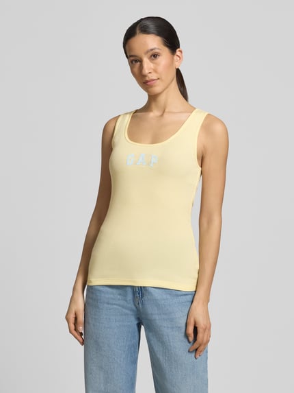 Vrouwenmodel draagt Slim Fit Top met logo-print van GAP in lichtgeel, katoenmix, ronde hals, ruglengte maat S 58 cm, vooraanzicht van het hele lichaam