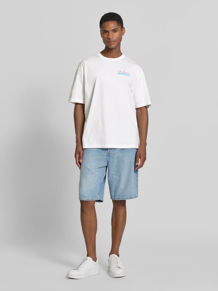 Männermodel trägt T-Shirt mit Statement-Print und Rundhalsausschnitt von MC2 Saint Barth aus Reine Baumwolle, Regular-Fit, Ganzkörperansicht von vorne. Rückenlänge bei Größe M: 71 cm.