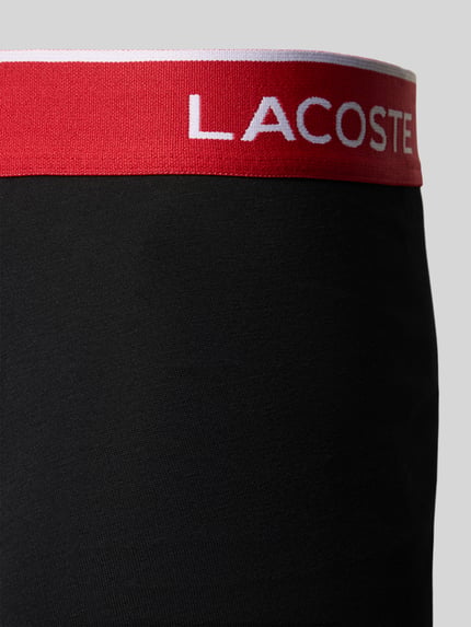 Produktfoto, Trunk aus Baumwoll-Mix im 5er-Pack von Lacoste, schwarze glatte Stoffstruktur, roter Bund mit weißem Logo, Herren Pant & Trunk von Lacoste