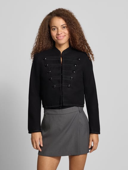 Frauenmodel trägt schwarzen Blouson mit Uniform Zierknöpfen Modell 'ONLNANCY' von ONLY, unifarben, Cropped, Ganzkörperansicht von vorne.