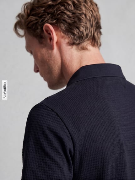 Männermodel trägt Regular Fit Poloshirt mit Strukturmuster von MCNEAL in Dunkelblau, elastischer Baumwoll-Mix, Nahaufnahme Rückansicht.
