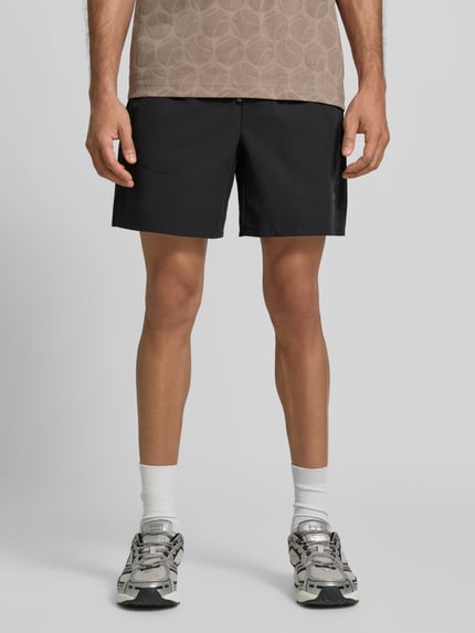 Männermodel trägt Relaxed Fit Sportshorts mit elastischem Bund von BOSS Green in Schwarz, glatte Textur, Ganzkörperansicht von vorne.