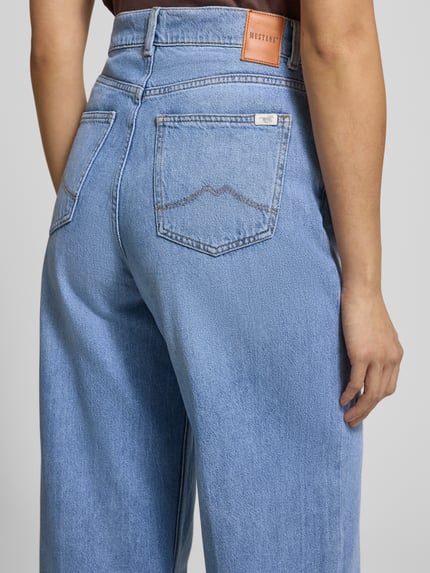 Kobieta modelka nosi jeansy Mustang, Jeans mit 5-Pocket-Design Modell 'Luise', luźny krój, jasnoniebieski, tkanina bawełniano-modalowa z lyocellem, detal z logo, widok całej sylwetki z tyłu.