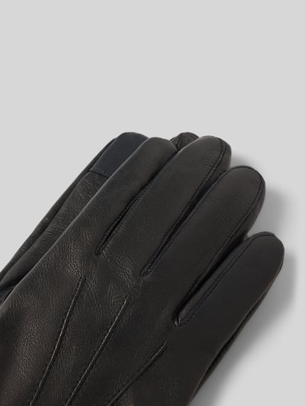 Produktfoto, Handschuhe aus echtem Leder mit Teilungsnähten von Akaroa, schwarze Farbe, sichtbare strukturierte Oberfläche, eingefasste Abschlüsse.