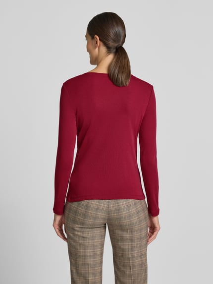 Frauenmodel trägt Slim Fit Longsleeve aus reiner Baumwolle von Christian Berg Woman in Rot, feine Struktur, taillierte Passform, Ganzkörperansicht Rückansicht.