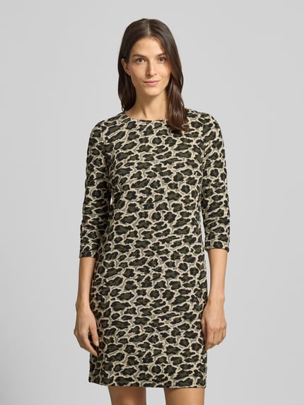 Frauenmodel trägt Minikleid mit Animal-Print von MONTEGO im Material-Mix mit Viskose-Anteil, Jacquard, U-Boot-Ausschnitt, 3/4-Arm, gerader-Schnitt, rückseitiger Reißverschluss, Creme- und Schwarztöne, strukturierte Textur, Ganzkörperansicht von vorne.