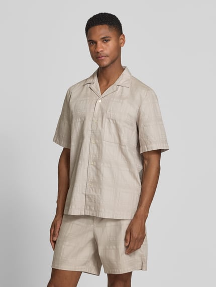 Männermodel trägt Regular Fit Freizeithemd aus reiner Baumwolle Modell 'RAYER_M' von BOSS Orange, Optik: Unifarben, Struktur, Label-Applikation, Reverskragen, Kurzarm, Brusttasche, Ganzkörperansicht von vorne.