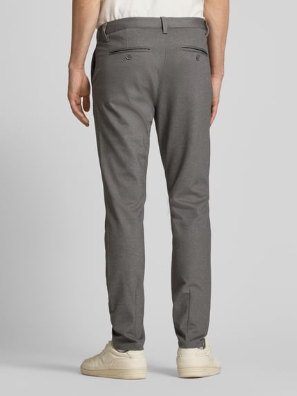 Männermodel trägt Slim Fit Chino aus Viskose-Mix Modell 'MARK' van Only & Sons, melange, unifarben, knoopsluiting, riemlussen, achterzakken, zijzakken, labelapplicatie, Ganzkörperansicht Rückansicht.