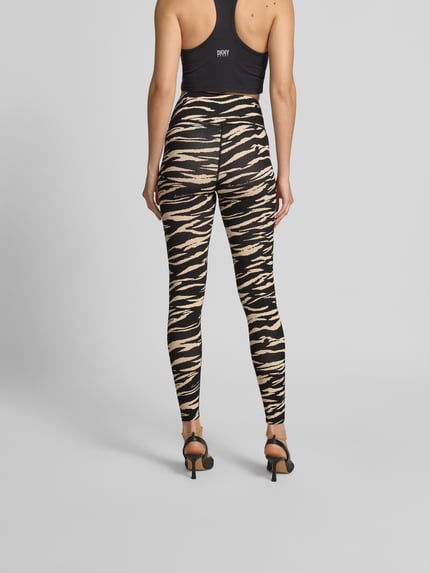 Frauenmodel trägt Slim Fit Leggins aus Viskose-Mix von Lala Berlin mit Allover-Animal-Print, Logo-Detail, Knöchellänge, Ganzkörperansicht Rückansicht.