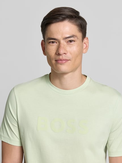 Männermodel trägt Regular Fit T-Shirt aus reiner Baumwolle Modell 'TE_LOGO' von BOSS Orange, Optik: Unifarben, Logo-Print, Nahaufnahme Oberkörper.