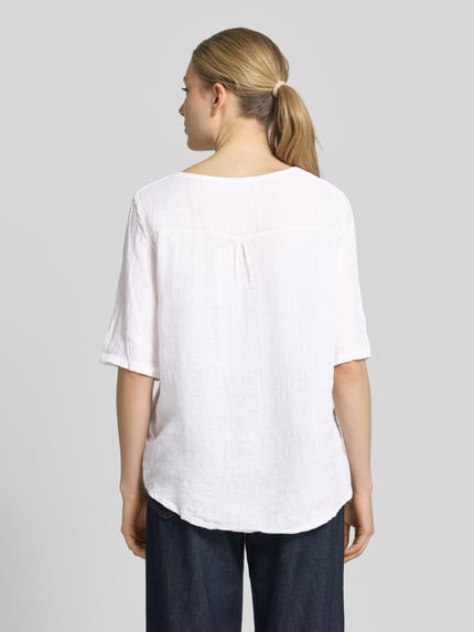 Frauenmodel trägt Blusenshirt mit Stitchings Modell 'No44raa' von ZABAIONE, weiß, 1/2-Arm, Relaxed-Fit, Rückansicht, Rückenlänge 66 cm, Ärmellänge 30 cm, Rundhalsausschnitt, Struktur mit leichter Textur. Ganzkörperansicht Rückansicht.