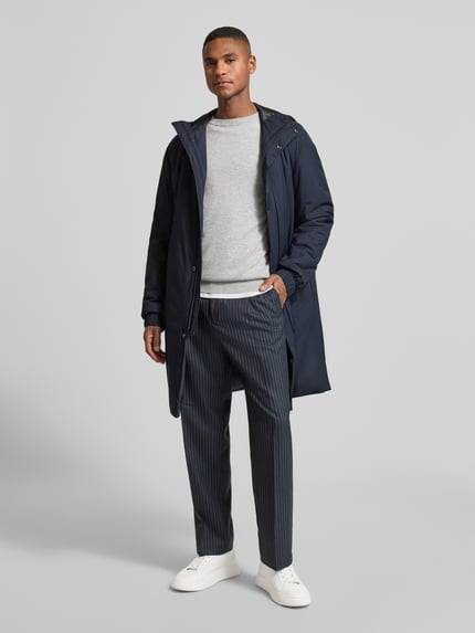 Männermodel draagt Regular Fit Mantel met waterafstotende functie model 'P-JARED-HD-PAD-261F' van BOSS, donkerblauw, unikleuren, lange mouwen, capuchon met tunnelkoord, label-stiksel, labelreliëf, drukknopen, verborgen rits, zijzakken, binnenzak, elastische mouwuiteinden, vooraanzicht hele lichaam.