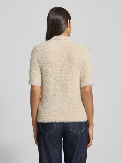 Frauenmodel trägt Strickpullover mit 1/2-Arm und Knopfleiste von Christian Berg Woman, cremefarben, feine Textur, Ganzkörperansicht Rückansicht. Slim Fit, Rundhalsausschnitt, Rückenlänge 63 cm, Ärmellänge 29 cm.