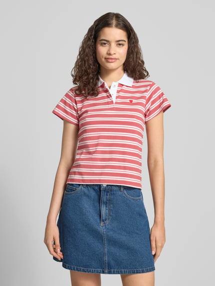Frauenmodel trägt Slim Fit Poloshirt mit Stitching von REVIEW, rosa-weiß gestreift, Reine Baumwolle, verdeckte Knopfleiste, Ganzkörperansicht von vorne, Rückenlänge bei Größe S: 49 cm.
