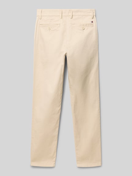 Productfoto, Regular Fit Chino uit katoenmix van Tommy Hilfiger Teens in effen beige met logostiksel, riemlussen en steekzakken.