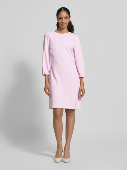 Frauenmodel trägt Knielanges Kleid mit Rundhalsausschnitt und 3/4-Arm von Marc Cain, Material-Mix mit Stretch-Anteil, Gerader-Schnitt, Rosa-Ton, Knielänge, Rundhalsausschnitt, 3/4-Arm, Rückenlänge 95 cm bei Größe 36, Brustweite 43 cm, Ärmellänge 53 cm, glatte Textur, Ganzkörperansicht von vorne.