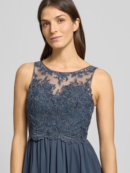 Frauenmodel trägt Regular Fit Abendkleid mit floralem Spitzenbesatz von Laona, semitransparent, Ziersteinbesatz, Nahaufnahme Oberkörper.