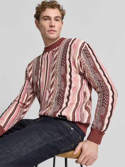 Männermodel trägt Regular Fit Strickpullover aus reiner Baumwolle von COLUCCI in Rot- und Beigetönen, Musterstruktur, Ganzkörperansicht von vorne.
