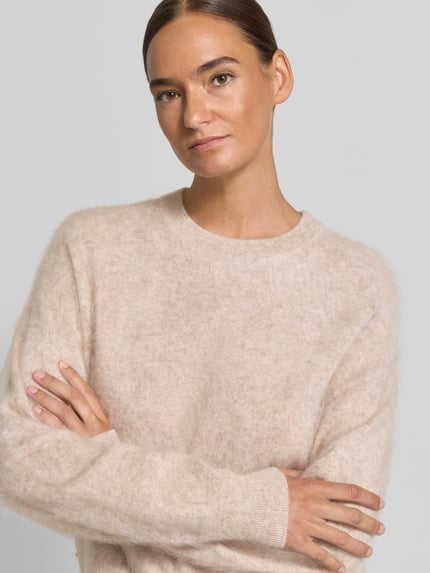 Frauenmodel trägt Regular Fit Pullover aus reinem Kaschmir von Jake*s Casual in hellem Beige, weiche Textur, Nahaufnahme Oberkörper.