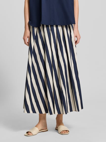 Vrouwenmodel draagt Ausgestellter Maxi-Rock aus reiner Baumwolle van Weekend Max Mara met all-over motief, regular fit, uitlopend model, maxilengte, elastische boord, rechte zoom, zij-steekzakken, puur katoen, kleur donkerblauw en gebroken wit, detailopname onderlichaam, vooraanzicht.