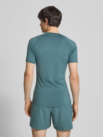 Männermodel trägt T-Shirt mit Logo-Print und Rundhalsausschnitt von NIKE TRAINING in Slim Fit, Raglanärmel, Rückansicht, Ganzkörperansicht.
