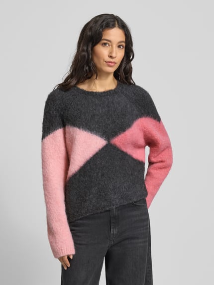 Modelka kobieca nosi Strickpullover mit Rundhalsausschnitt od Smith and Soul, materiał z domieszką moheru, luźny krój, wzór geometryczny, perspektywa z przodu, zdjęcie w półzbliżeniu.