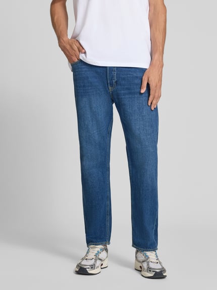 Mężczyzna nosi Straight Fit Jeans aus Baumwoll-Mix Modell 'CHRIS' von JACK & JONES, mieszanka bawełny, krój straight fit, 5 kieszeni, zapięcie na guzik i zamek błyskawiczny, szerokość w rozmiarze 32/32: 41 cm, długość wewnętrzna nogawki 72 cm, granatowy denim, widoczne przeszycia, widoczne kieszenie, całkowity widok z przodu.