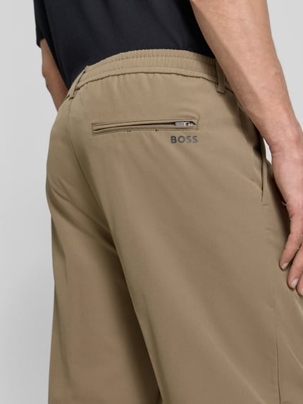 Männermodel trägt Tapered Fit Anzughose aus bügelleichtem Material Modell 'T_CONVERT' von BOSS Green, Detailaufnahme Rückansicht.