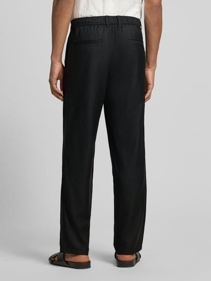 Männermodel trägt HOSE mit Eingrifftaschen Modell 'NOAH' von Samsøe Samsøe, Reine Baumwolle, Straight, Schwarz, Ganzkörperansicht Rückansicht.