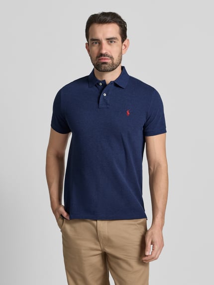 Mężczyznamodel nosi Koszulkę polo z wyhaftowanym logo Polo Ralph Lauren z bawełny, krój regular fit, kołnierzyk polo, krótkie rękawy, niebieski kolor, prążkowane zakończenia rękawów, długość tyłu 68 cm dla rozmiaru M, widok całej sylwetki z przodu.