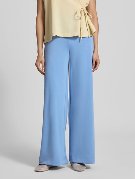 Frauenmodel trägt Sweatpants mit Stretch-Anteil von Milano Italy in Hellblau, lockere Passform, elastischer Bund, weites Bein, Nahaufnahme Unterkörper. Modal-Elasthan-Mix, Eingriff- und Gesäßtaschen sichtbar.
