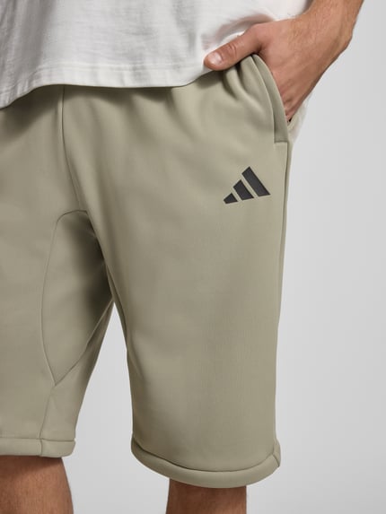 adidas Sportswear Spodnie dresowe o kroju relaxed fit z nadrukiem z logo Trzcinowy 3