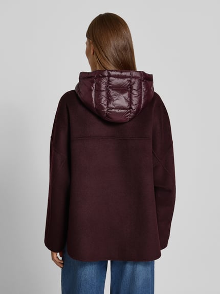 Frauenmodel trägt Jacke mit Kapuze von COMMA in Dunkelrot, lockere Passform, gesteppte Kapuze, Rückansicht, Ganzkörperansicht Rückansicht.