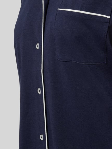 Frauenmodel trägt Regular Fit Pyjama-Oberteil mit Brusttasche von Christian Berg Woman aus Baumwoll-Modal-Mix in Dunkelblau, Nahaufnahme Oberkörper.