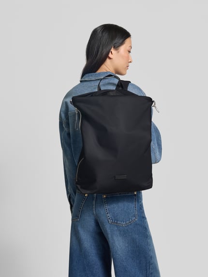 Frauenmodel trägt Rucksack mit verstellbaren Schulterriemen von Marc O'Polo in Schwarz, Logo-Applikation, Hauptfach, Reißverschluss, Ganzkörperansicht Rückansicht