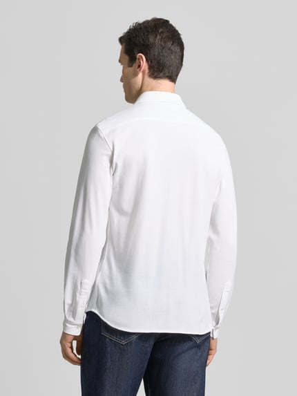 Männermodel trägt Slim Fit Freizeithemd aus reiner Baumwolle von Lacoste in Weiß, Optik: Unifarben, Materialverarbeitung: Piqué, Ganzkörperansicht Rückansicht.